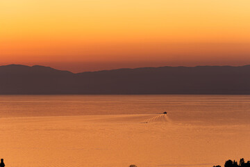 Un bateau naviguant sur un lac sous un couché de soleil