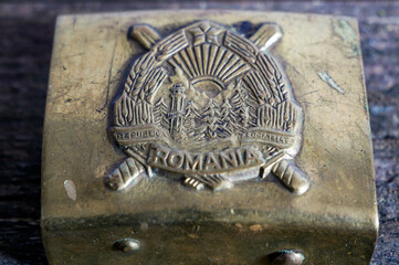 Old romanian socialist crest on copper buckle close up shot.