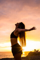 Portrait of active young woman enjoying the sunset outdoor during sport exercises - concept of...