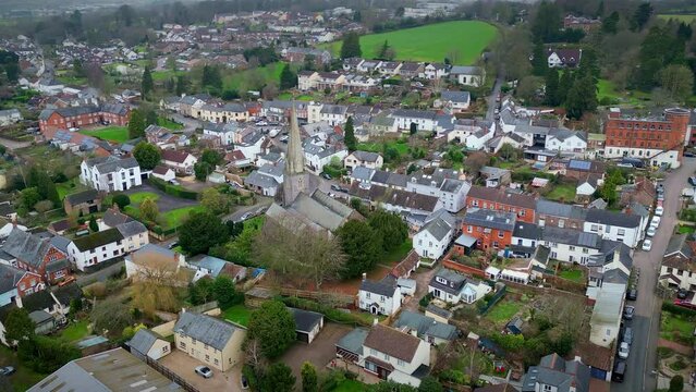 Oribital aerial drone flight around St Mary's Church in the rural village of Uffculme in Mid Devon in the West of England incorporating the village centre and surrounding countryside