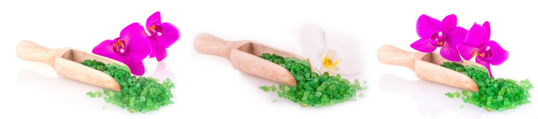 Set of green sea salt in wooden spoon and flower on white background