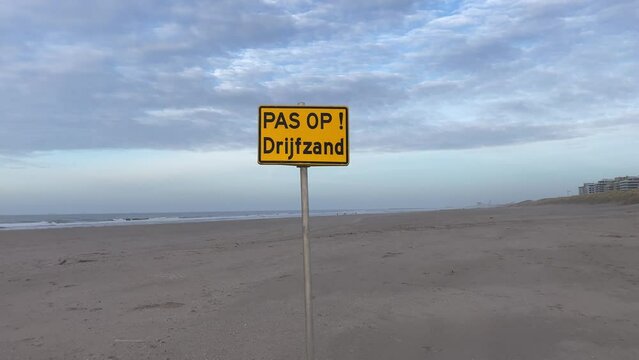 Danger quicksand sign at Kijkduin beach near zandmotor on Dutch North Sea Coast