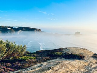 Naklejka premium Fog at the ocean coast, ocean bay in the fog, impressive view