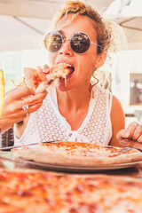 Beautiful adult caucasian woman eating italian food pizze - man couple point of view with beer and...