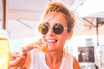 Beautiful adult middle age beautiful woman enjoying tasty italian natural pizza at the restaurant...