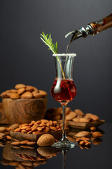 Italian liqueur Amaretto with almonds nuts on a black background.