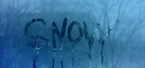 the word snow on wet glass. the concept of winter