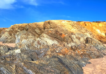 Colorful slate natural rocks at the beach of Vila Nova de Milfontes in Portugal