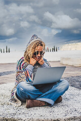 Happy and free digital nomad alternative woman working with technology everywhere in the world traveling a lot - travel lifestyle with laptop computer modern job - people connected outdoor