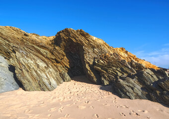 Obraz premium Colorful slate natural rocks at the beach of Vila Nova de Milfontes in Portugal
