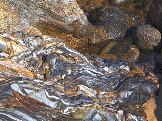 Colorful slate natural rocks at the beach of Vila Nova de Milfontes in Portugal