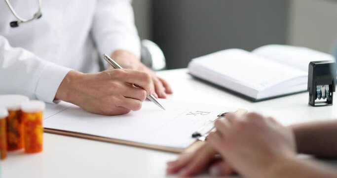 Doctor writing paper prescription to female patient in clinic closeup 4k movie slow motion. Implementation of medical recommendations concept