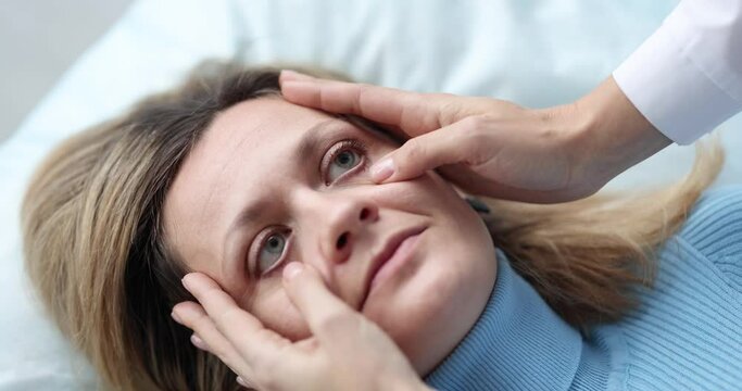Doctor examining eyes of sick female patient in clinic 4k movie slow motion. Pupil reaction to light symptoms of brain disease concept