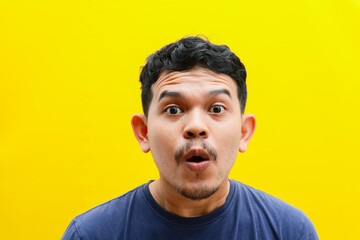 Portrait of the face of an Asian young man with a shocked expression. Studio shoot