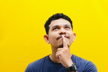portrait of the face of an Asian young man who is thinking hard. studio shoot