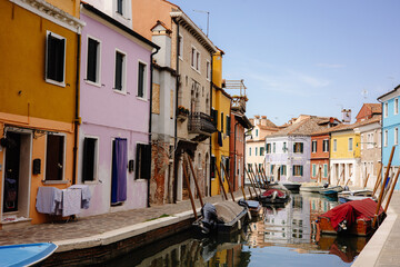 Fototapeta na wymiar Colorful Canals of Burano, Italy - Picturesque Scene with Boats and Houses Reflecting in Water