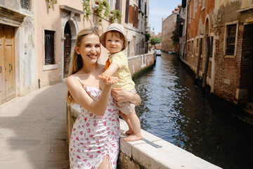 Mother and Son Delighting in a Memorable Vacation Exploring the Charming Canals of Venice, Italy © sorin
