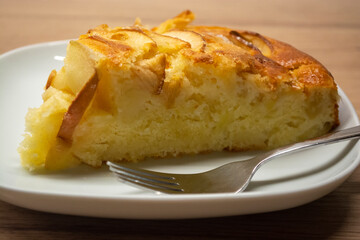 A piece of apple pie on a white plate and a fork. Baking Apple Pie