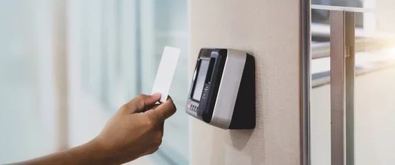 Fotobehang Proximity card door unlock, Hand security man using ID card on fingerprint scan reader access control system for identity verification to open the door or for security safety or check attendance. © Eakrin