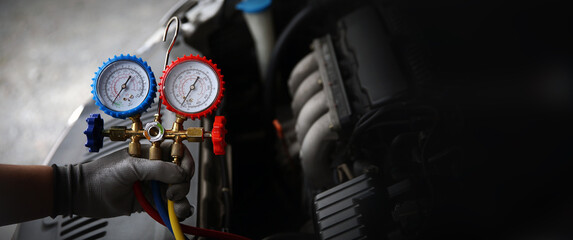 Hand technician auto mechanic using measuring manifold gauge with car care maintenance and service for check refrigerant and filling car air conditioner to fix repairing heat conditioning system. - obrazy, fototapety, plakaty