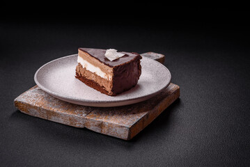 Piece of delicious sweet chocolate cake with sponge cake and cream