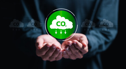 Reduce CO2 emissions. Person holding virtual carbon reduction icon. Climate change to limit global warming and sustainable development and green business.