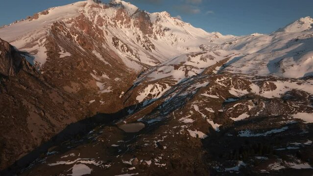 Aerial view of rocky snowy mountains in Albanian Alps, Mt korab summit during sunset