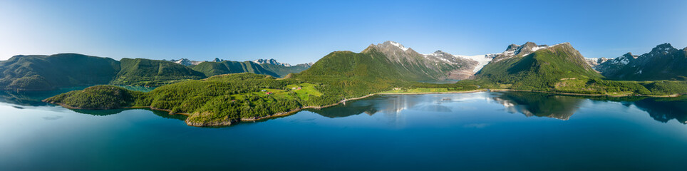 Naklejka na ściany i meble Expansive hyper panorama of Svartisen Glacier, where the pristine waters of the fjord flawlessly reflect the Saltfjell mountain range under the clear Norwegian sky