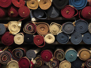 A front on view of a variety of tightly rolled colorful handmade authentic traditional patterned...