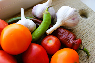 Set of vegetables for preparing spicy tomato sauce on a wooden kitchen board