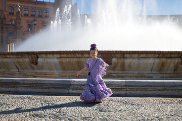 Girl dancing flamenco, turning to show off her costume, with typical flamenco dress next to a spectacular fountain in a beautiful square in Seville. Dance concept, flamenco, typical Spanish, Spain. - obrazy, fototapety, plakaty