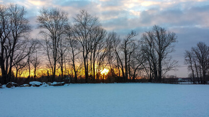 Sunrise over a snow covered field.