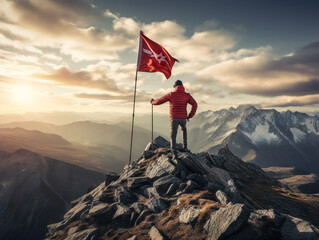 Obraz premium A triumphant hiker plants a flag on a snowy mountain peak with breathtaking panoramic views.