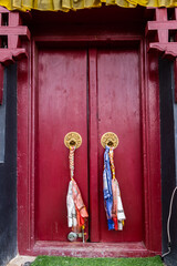 Low-angle shot of a red door with golden knockers - Ancient architecture concept.