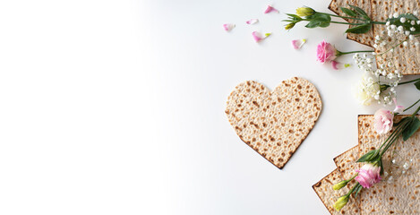 Passover. banner of Traditional Matzo shape of heart  decorate by pink flowers on white background....