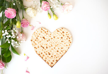Passover. banner of Traditional Matzo shape of heart  decorate by pink flowers on white background. top view. Holiday of Jewish people, Spring Holiday. Fasting time