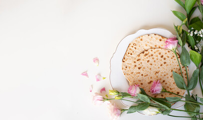 Passover. Holiday of Jewish people. Traditional Matzo prepared for Passover decorate by flowers on white background. banner. top view. Spring Holiday. Fasting time
