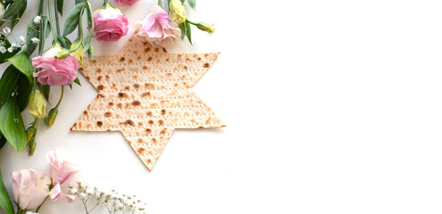 Passover. banner of Traditional Matzo shape of star Magen David  decorate by pink flowers on white background. top view. Holiday of Jewish people, Spring Holiday. Fasting time