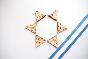 Passover. banner of Traditional Matzo shape of six triangles star Magen David  decorate by two blue line  on white background. top view. Copy space for text. Holiday of Jewish people, Spring Holiday.