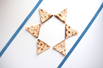 Passover. banner of Traditional Matzo shape of six triangles star Magen David  decorate by two blue line  on white background. top view. Copy space for text. Holiday of Jewish people, Spring Holiday.