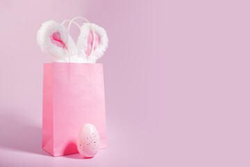 Easter egg surprise, shopping bag with bunny ears, pink background, spring sale
