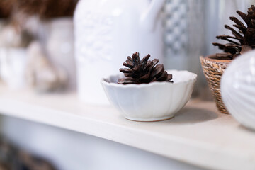 Pine cones in white cups and woven baskets for home or cafe decoration