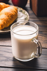 Glass mug with milk on wooden table