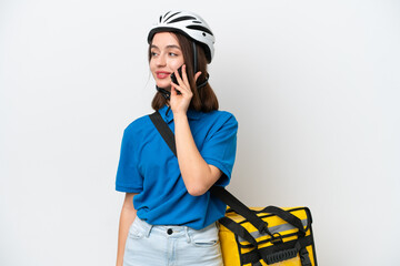 Young Ukrainian woman with thermal backpack isolated on white background keeping a conversation with the mobile phone with someone