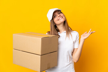 Young Slovak delivery woman isolated on yellow background extending hands to the side for inviting...
