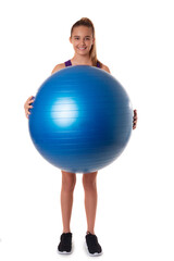 Slim and fit teen girl holding a swiss blue ball. Full length shot on white background.