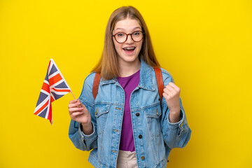Teenager Russian girl holding an United Kingdom flag isolated on yellow background celebrating a...