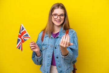 Teenager Russian girl holding an United Kingdom flag isolated on yellow background inviting to come...
