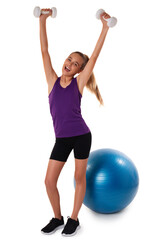 Slim and fit teen girl holding a dumbbells with arms up. Swiss blue ball on background. Full length shot on white