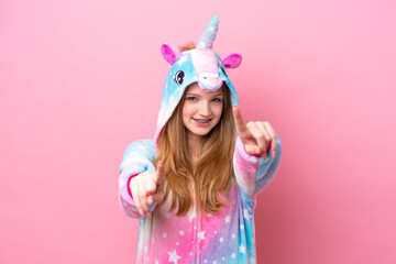 Obraz na płótnie Canvas Teenager Russian girl with unicorn pajamas isolated on pink background points finger at you while smiling